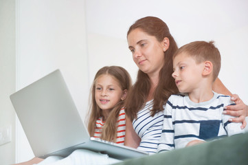 Fototapeta na wymiar beautiful family mother and children watching on laptop screen internet online