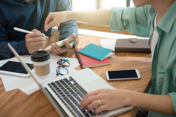 business team  briefing marketing strategy with smart phone, tablet, notebook, and laptop on wooden desk with,Freelance work at home office. Writing note on a book.