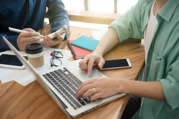 business team  briefing marketing strategy with smart phone, tablet, notebook, and laptop on wooden desk with,Freelance work at home office. Writing note on a book.