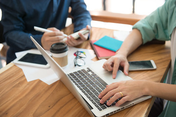 business team  briefing marketing strategy with smart phone, tablet, notebook, and laptop on wooden desk with,Freelance work at home office. Writing note on a book.