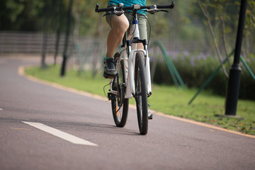 Fototapeta na wymiar Free woman cyclist riding bike in spring tropical park