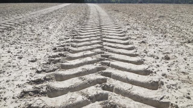 Large tire tracks in dirt field