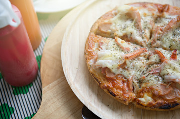 Close up seafood pizza that combined with shrimp crap and squid on wooden plate and pizza paddle