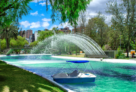 View of the lagoon with a fountain and a catamaran with pedals (water bicycle), in the public park of La Carolina in the north of the city of Quito. Ecuador.