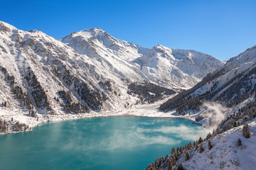 Fototapeta na wymiar Satpayev peak (4317 m) and emerald Big Almaty Lake at winter season. Tian Shan mountains, Kazakhstan.