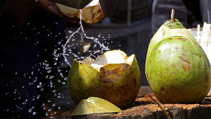 Heat, thirst, desire to drink. Chopping coconut at the fruit market on a hot day.