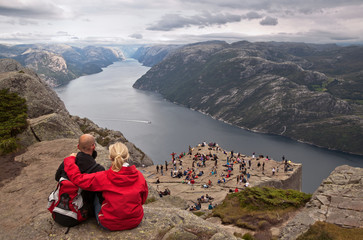 Group of tourists enjoy breathtaking views from Preikestolen  rock, Norway.