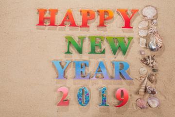 colorful of alphabet happy new year 2019 on the beach decorate with shells with copy space.