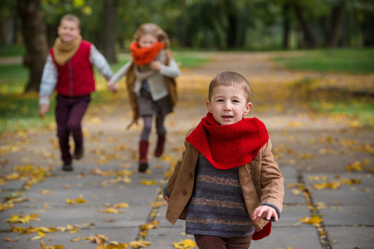 Happy children play and run in autumn park