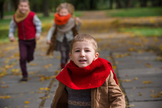 Happy children play and run in autumn park