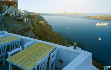 open air cafe with beautiful view early in the morning with soft sunlight in Santorini, Greece