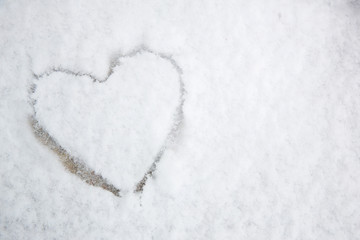 The symbol of the heart, painted on the fresh white snow.drawn heart in the snow.Image of the heart in the snow.