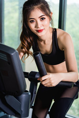 Fototapeta na wymiar Female woman lifestyle using equipment machine exercise bike for training cardio workout
