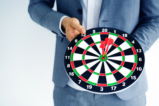 Businessman holding a dart board The traces of many games. The competition in the business world requires expertise and understanding of the target audience to succeed at strategic planning.