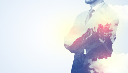 Businessman standing and thinking with snowy mountain graphic