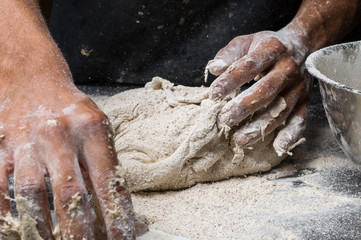 Fototapeta premium Male hands kneading dough on sprinkled