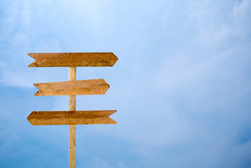Empty signage isolated blue sky background. three way wooden sign isolated on sky