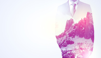  Young businessman in suit standing with sunny snowy mountain and trees graphic.