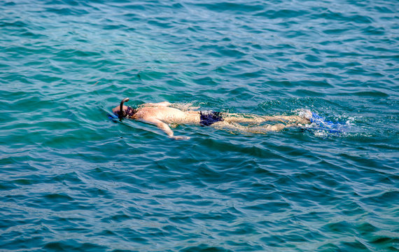 Tourist snorkeling swims in the sea water