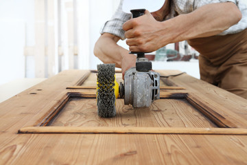 carpenter work the wood with the sander grinding electric tools for rustic wooden effects