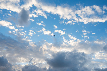 The helicopter in the sky, among beautiful clouds.