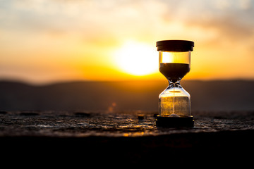 Hourglass Passing of Time Lapse Clouds. An hourglass in front of a bright blue sky with puffy white...