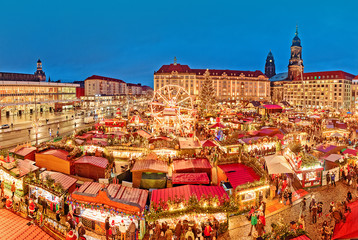 Dresden in Christmas time, Germany. Spectacular view on famous traditional European Christmas market on the central city square, dusk scenery, illuminated stalls and market places, amusement park.