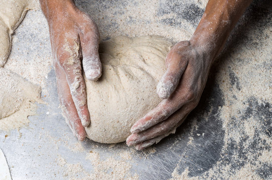 Male hands kneading dough on sprinkled