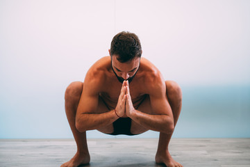 Yoga. Young man doing yoga exercise isolated on a white background. Yogi master workout on white urban studio. Yoga lifestyle healthy concept.