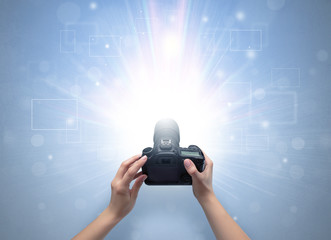 Naked hand taking picture with digital camera and glowing flash concept
