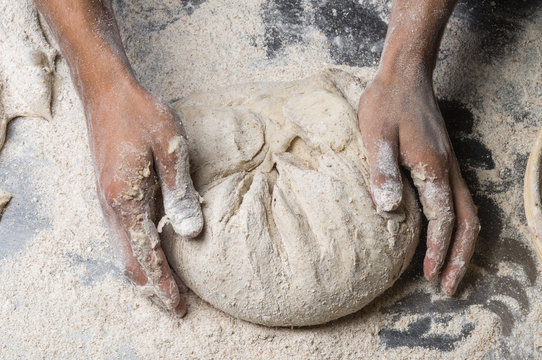 Male hands kneading dough on sprinkled