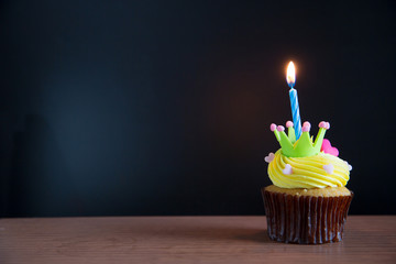 Birthday cupcake with a single blue candle.Cupcake with yellow cream and heart for love...