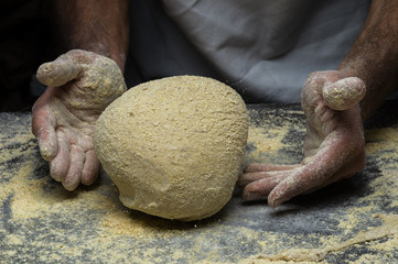 Male hands kneading dough on sprinkled