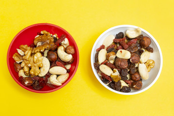 two colored bowls containing dried fruit