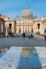 Rome, Italy. St. Peters basilica reflected in a puddle after rainб from St. Peter's square in...