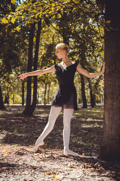 Ballerina dancing on the street.Young beautiful ballerina in dress and pointe shoes dancing outdoors. Ballerina posing in the center of Europe 