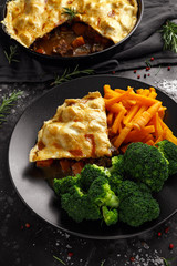 Traditional English beef beer, ale pie served with carrots and broccoli
