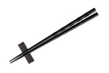 pair of black chopsticks with wood holder isolated on a white background