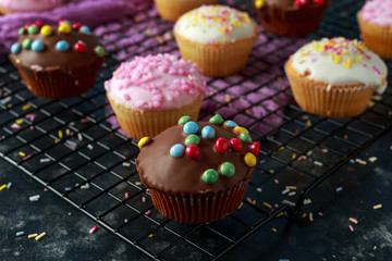 Sweet mini iced muffins, buns in a black background