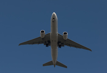Fototapeta na wymiar Passenger airplane flying on blue sky background is preparing to land