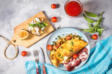 Breakfast mushrooms omelet and sandwich with figs on concrete background. Top view.