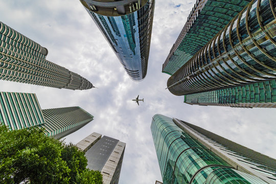 KUALA LUMPUR, 2 August 2018 - Up View Of Kuala Lumpur Skyline On The Tall Skyscrapers And Palm Trees And A Plane In The Sky, Malaysia