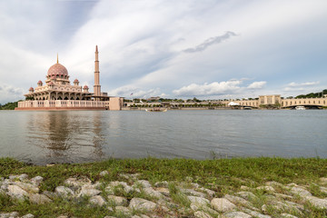 Fototapeta na wymiar Pink color Putrajaya mosque surrounded by water at Putra Jaya city, the Malaysian Federal Territory administrative city framed with space for text messages