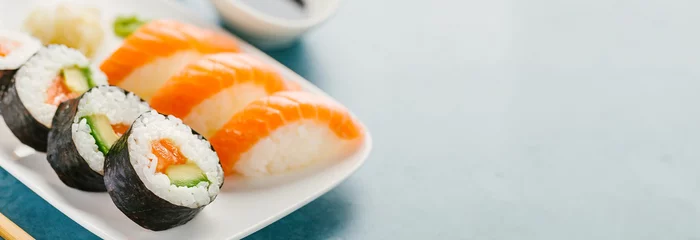 Selbstklebende Fototapeten Sushi serviert auf Teller auf blauem Tisch © nerudol