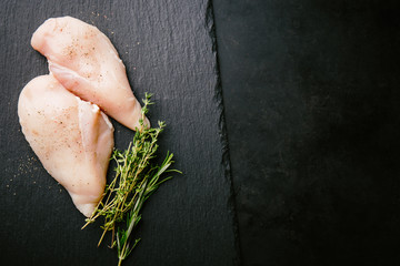 Raw chicken breast on dark background