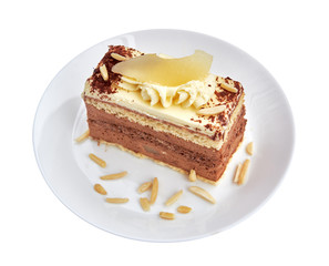 Chocolate mousse cake with cream, cacao, pear and almond on the white porcelain with white background. Close up.