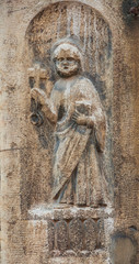 Saint Peter holding the Key of Heaven and the Bible, an ancient medieval relief on a wall in the historic center of Venice