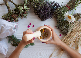 Grinding dried herbs with a mortar and pestle