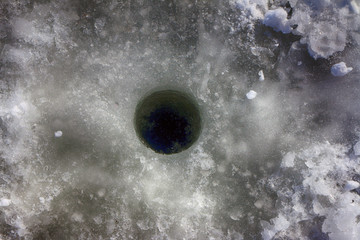 Ice hole in the pond ice