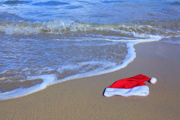 Santa Claus hat on caribbean beach. Christmas background